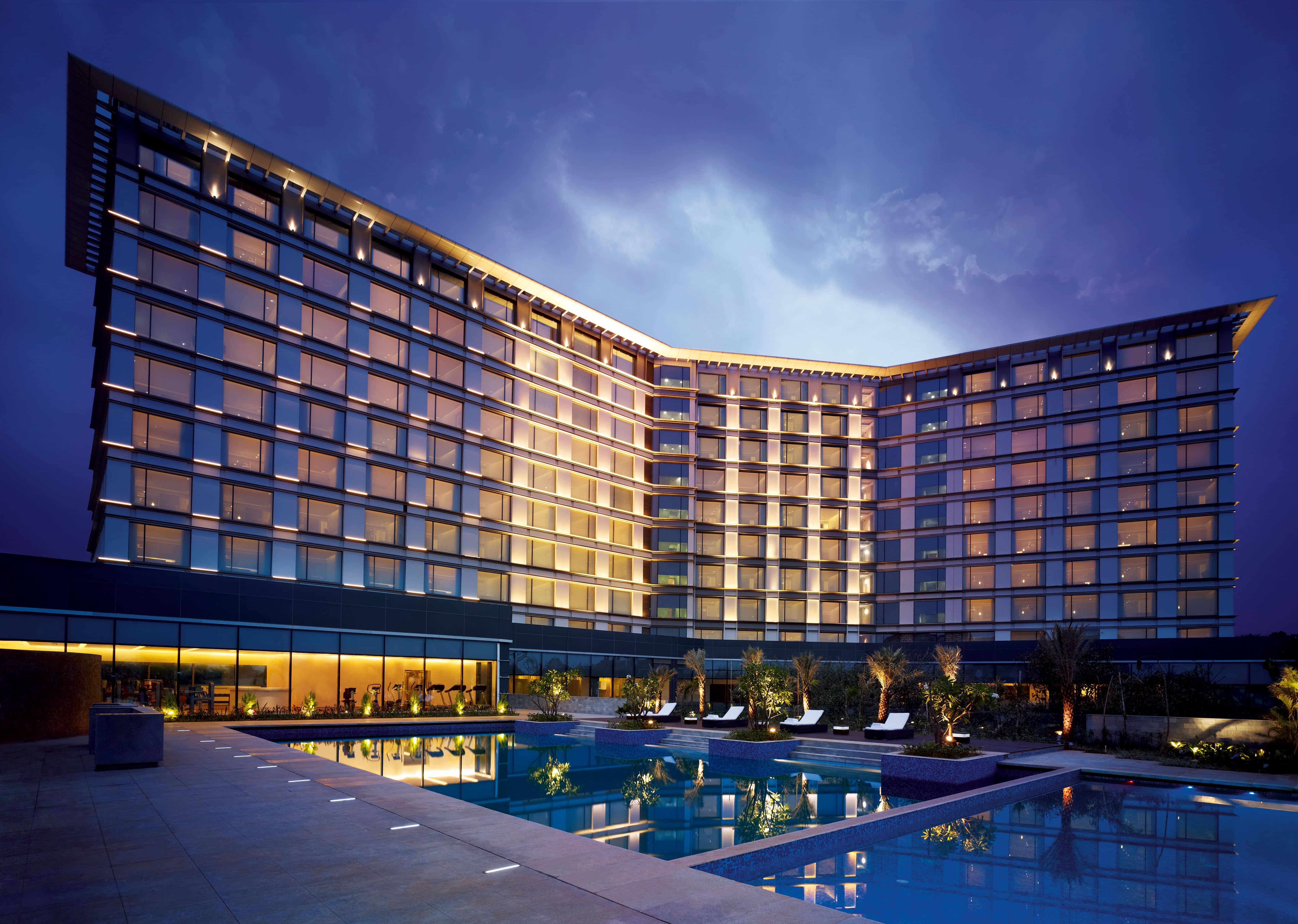 Illuminated exterior of Taj Yeshwantpur, Bengaluru, with the swimming pool in the foreground